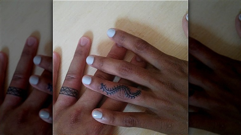couple wearing ring finger tattoos