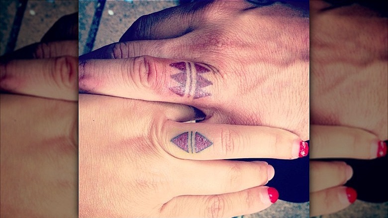 couple wearing wedding ring tattoos