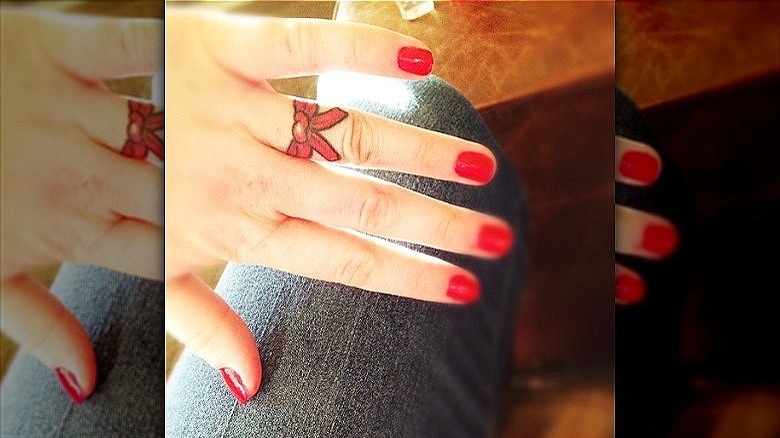 woman with bow wedding ring tattoo