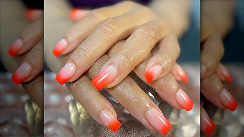 woman with orange fade nails