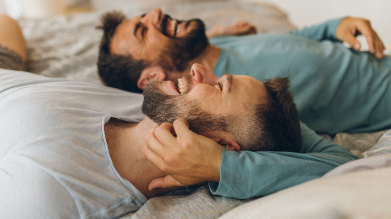 Couple happily lounges on bed