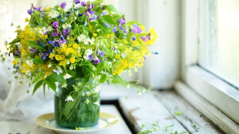 Flower arrangement in old candle jar