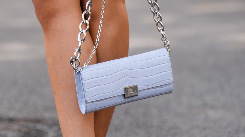 woman holding a crocodile bag