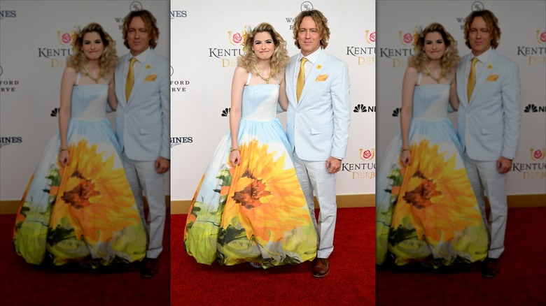 Dannielynn Birkhead stands next to Larry Birkhead wearing a sunflower-inspired ballgown