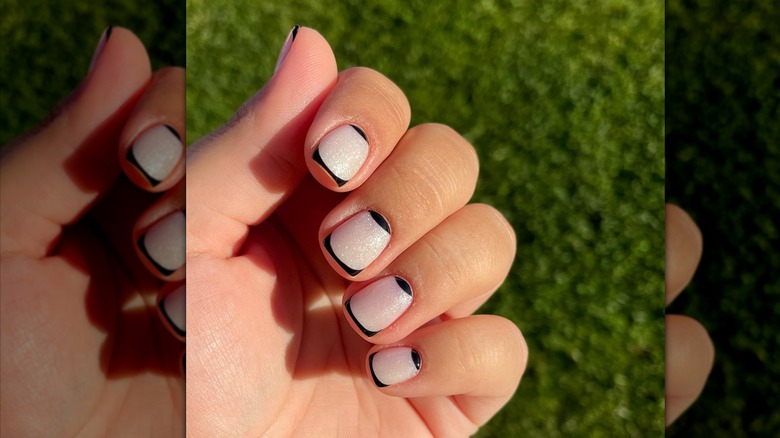 Hand with black French manicure