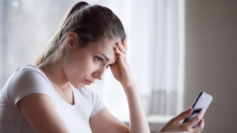Sad woman looking at phone 