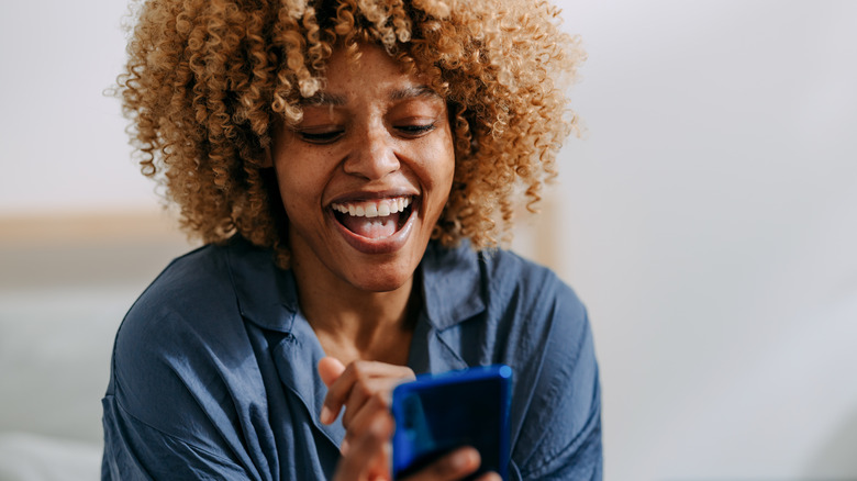 Woman reacting to information on phone screen