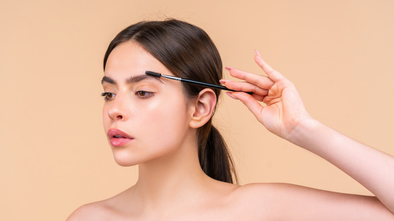 woman styling eyebrows