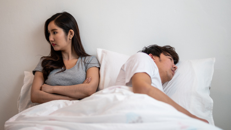 Couple in bed facing away from each other