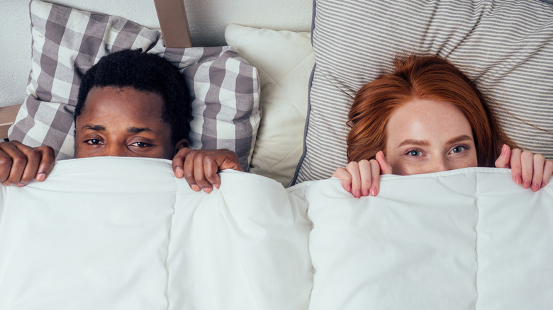 embarrassed couple in bed