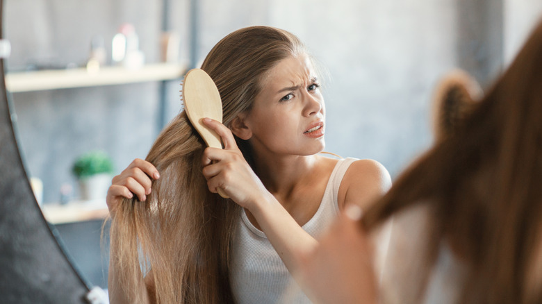frustrated woman brushing hair