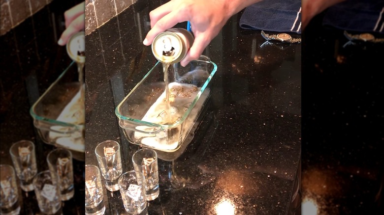 Hand pours beer over jewelry