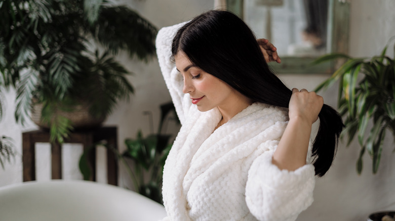 woman in bathrobe holdinh hair