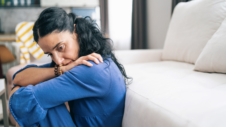 Sad woman sitting on floor