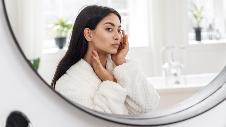 Woman admires makeup in mirror