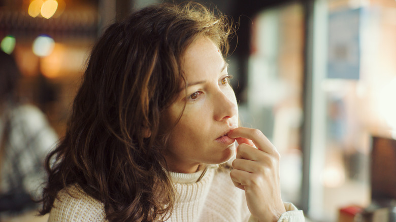 woman biting nails in bar