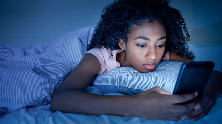 Woman browsing internet in bed