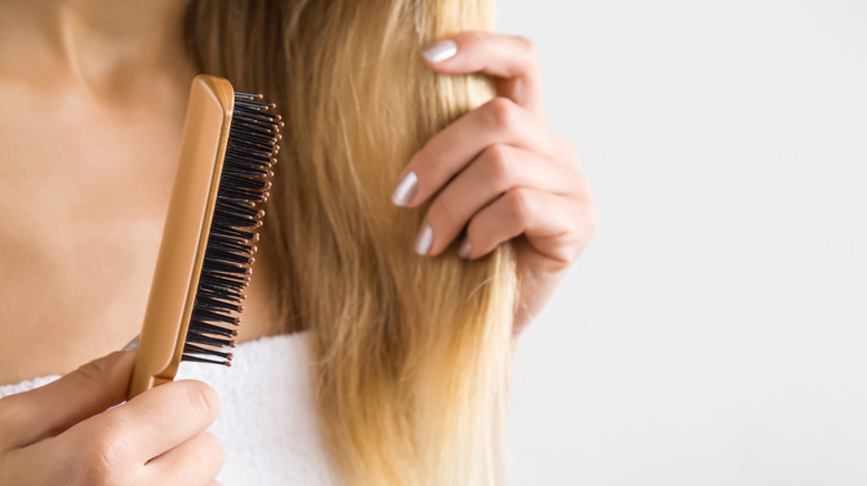 Woman brushing blond hair
