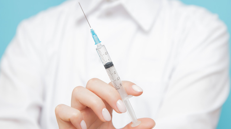 doctor holding syringe