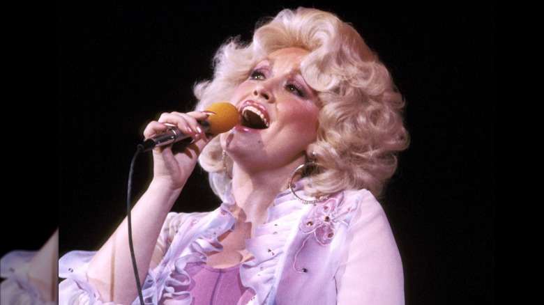 Dolly Parton singing with voluminous curls in the '70s