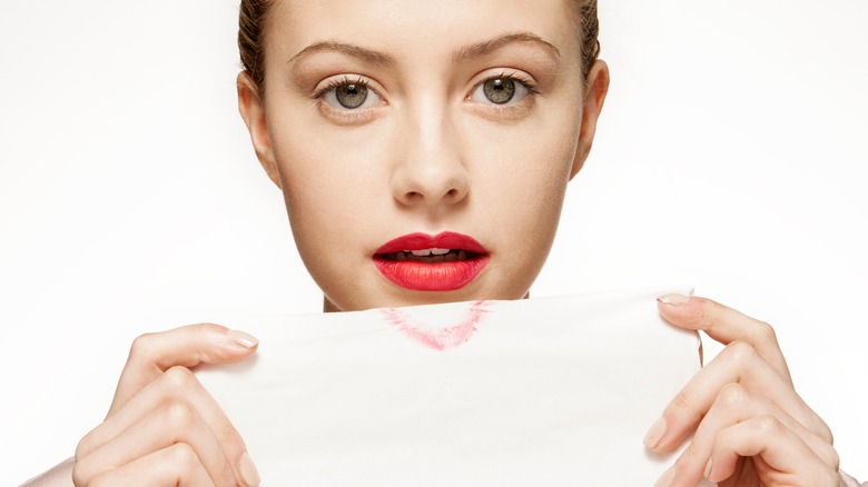 woman blotting lipstick