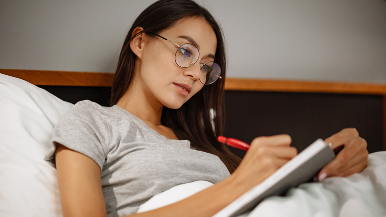 Woman journaling in bed