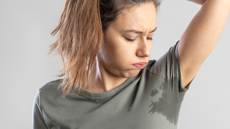 Woman with pit stains showing through her shirt.
