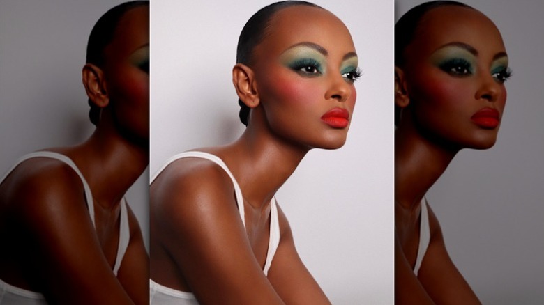 model posing with green eyeshadow and pink blush