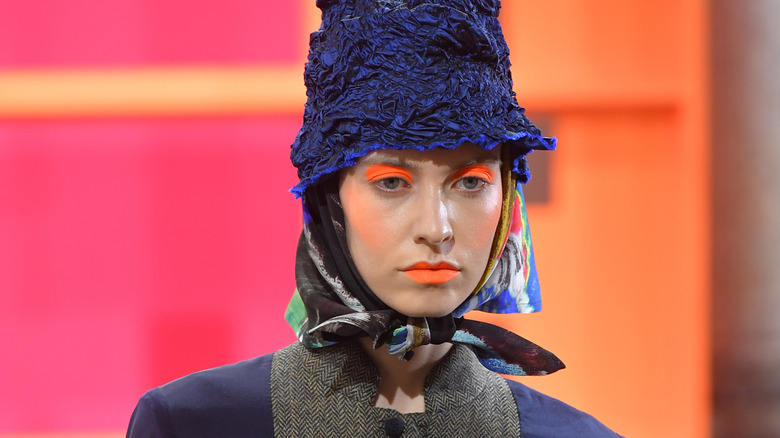 model wearing orange eyeshadow and lipstick