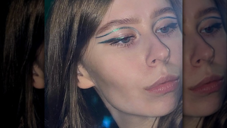 A woman wearing metallic green eyeliner.