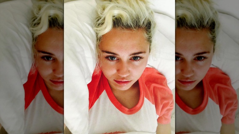 Miley Cyrus taking a selfie in bed with bleached hair