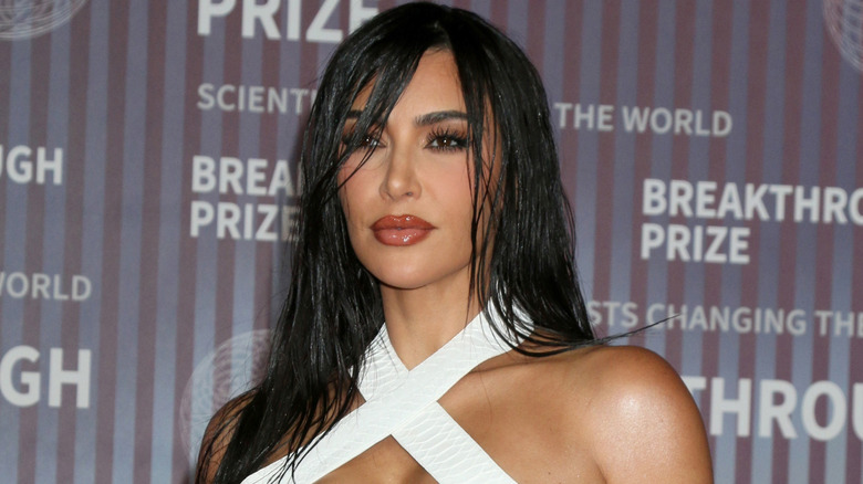 Kim Kardashian with radiant skin poses at the the 10th Annual Breakthrough Prize Ceremony in a white dress