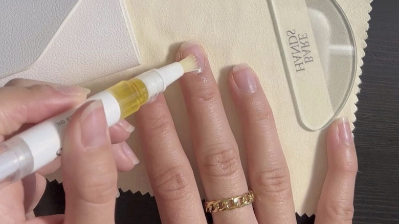 Person applying cuticle oil