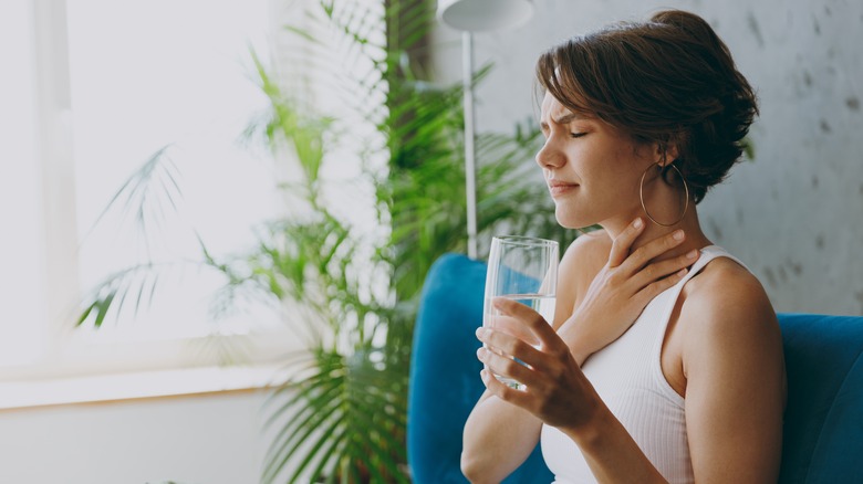 Woman struggling with esophagitis from pill