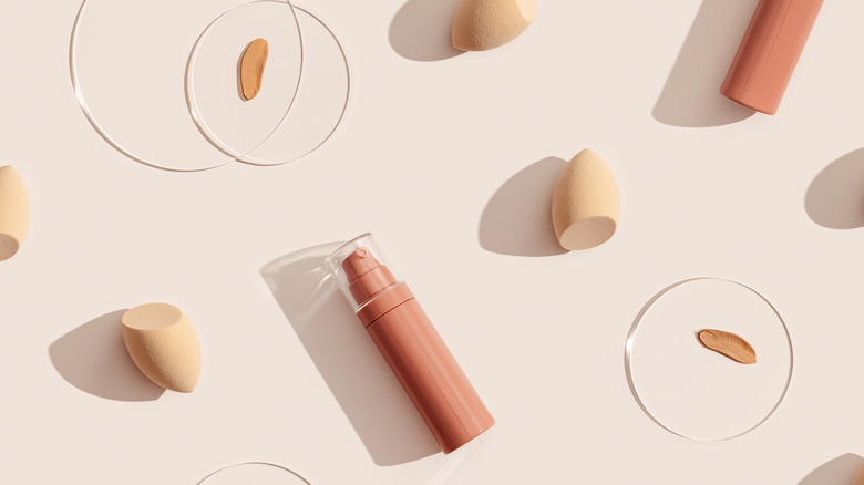 makeup products laid out on cream background