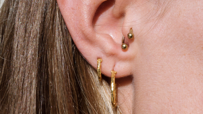 person with multiple earrings