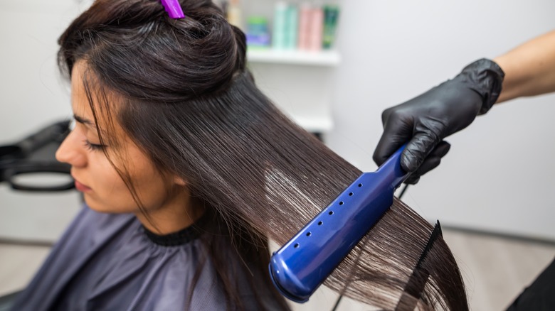 woman having hair straightened