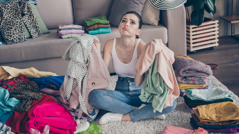 woman pouting holding clothes