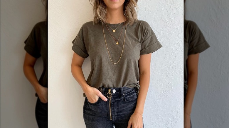 Woman wears black jeans with gold zipper