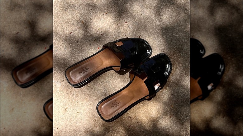 Hermes black slides on sand