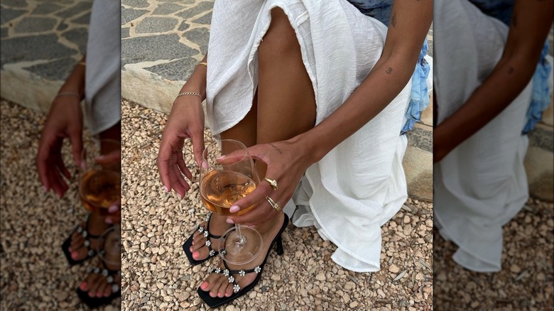 Woman wearing embellished black heeled slides