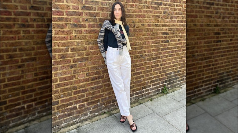 Woman wearing black, brown slides