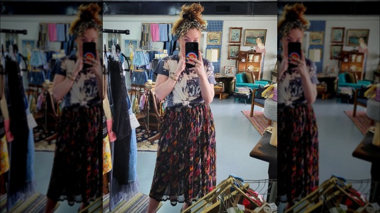 A woman wearing a skirt with a graphic tee