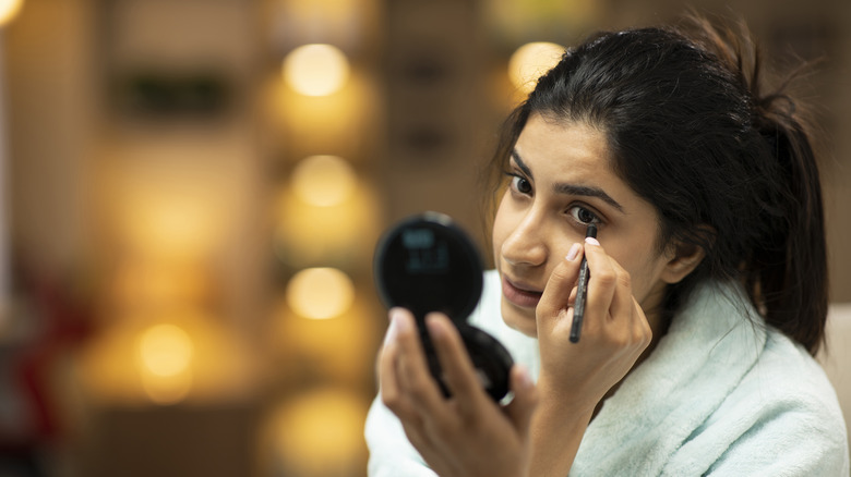 woman applying eyeliner