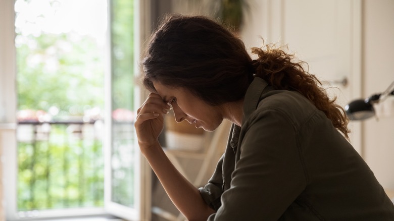 Sad woman with head in hands