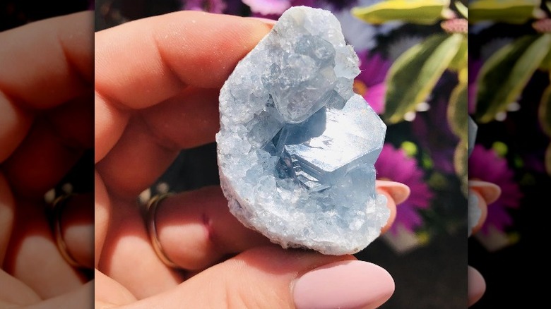 woman holding celestite crystal 
