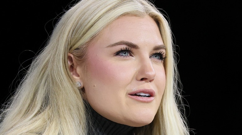 Close-up of Erika Kirk. She is wearing a full face of makeup with heavy blush, drawn-on brown eyebrows, and several thick layers of mascara.