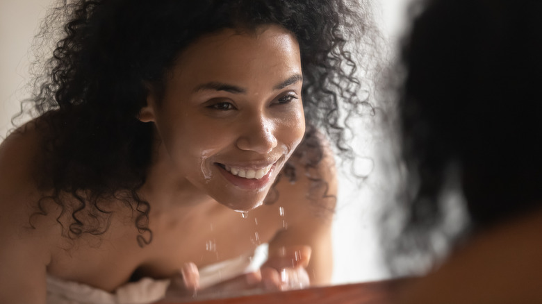 Woman cleanses face