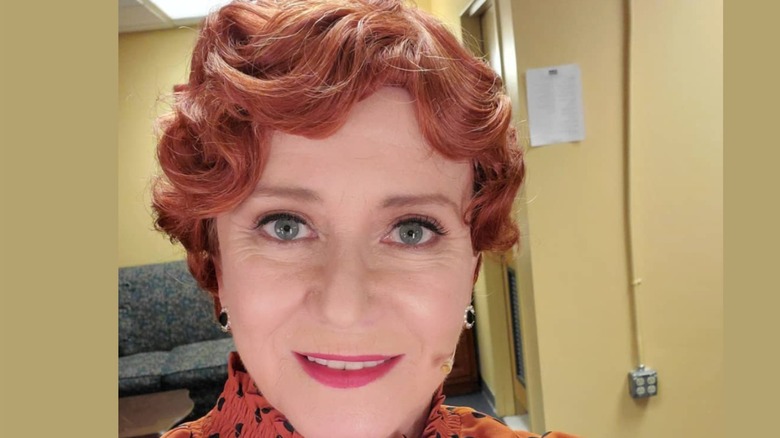 Eve Plumb wears a red wig while dressed in character for various stage and movie roles