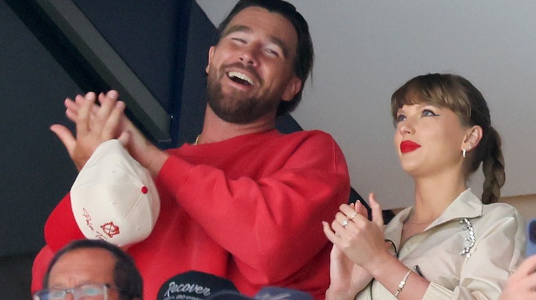 Travis Kelce and Taylor Swift clap at a baseball game